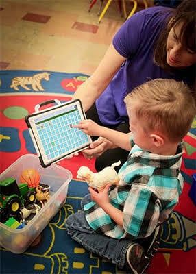 AAC assessment and communication device training session for children.